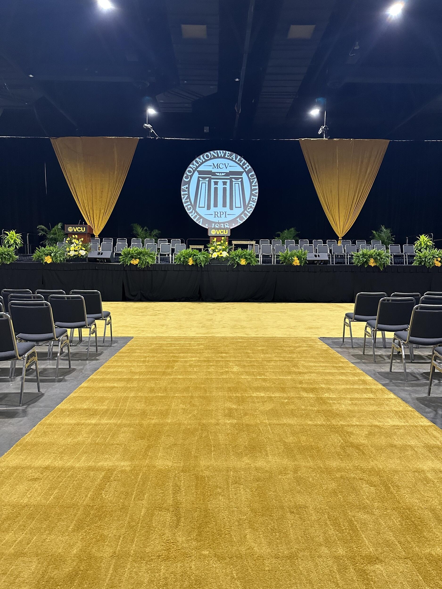A photo of yellow carpet leading up to a stage. 