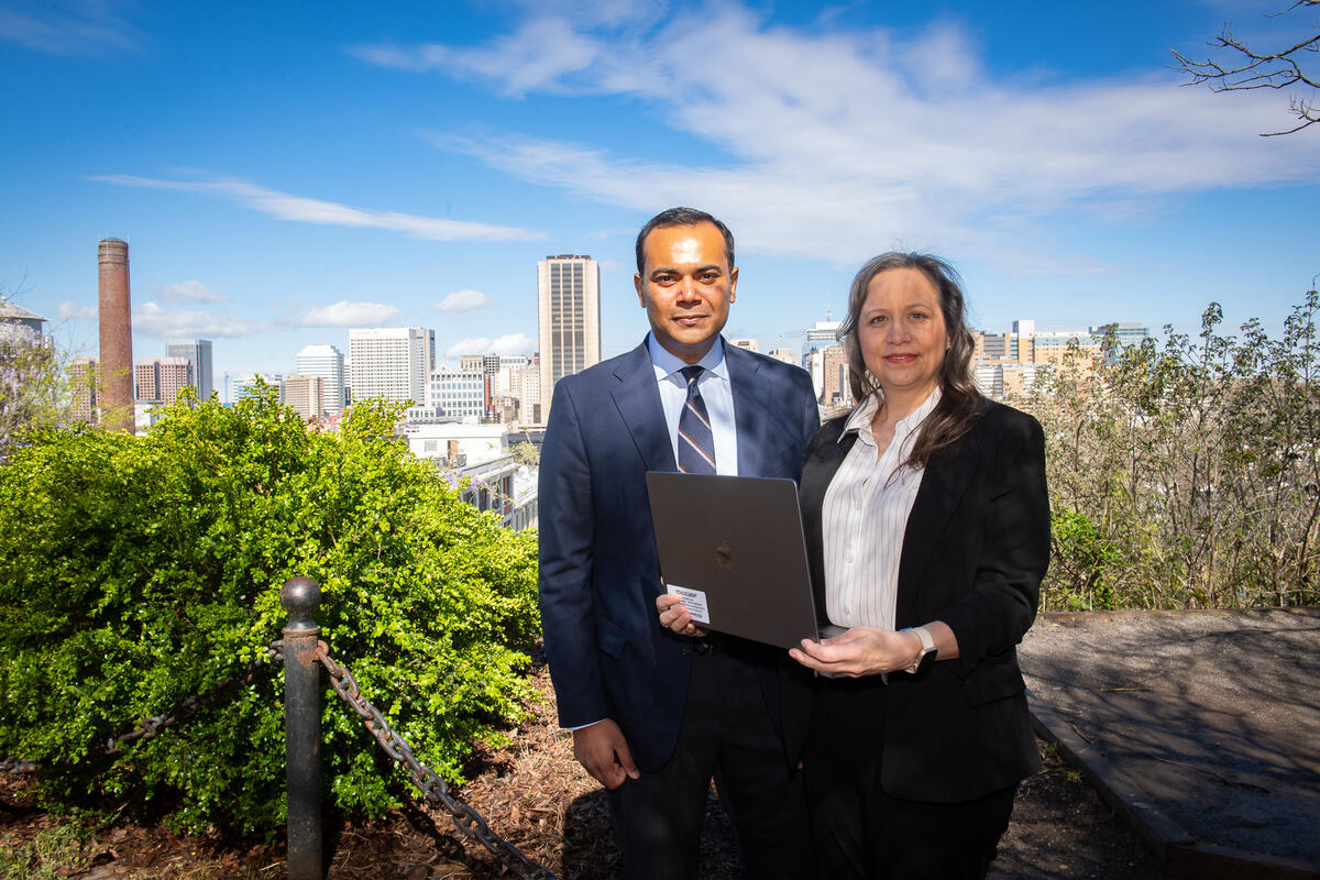 A photo of a man and woman standing in front of the Richmond skyline