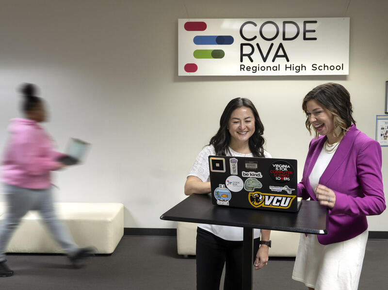 A photo of two women looking at a laptop