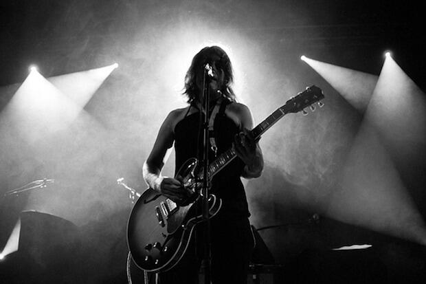 Rebecca Gates performing onstage, playing the guitar.