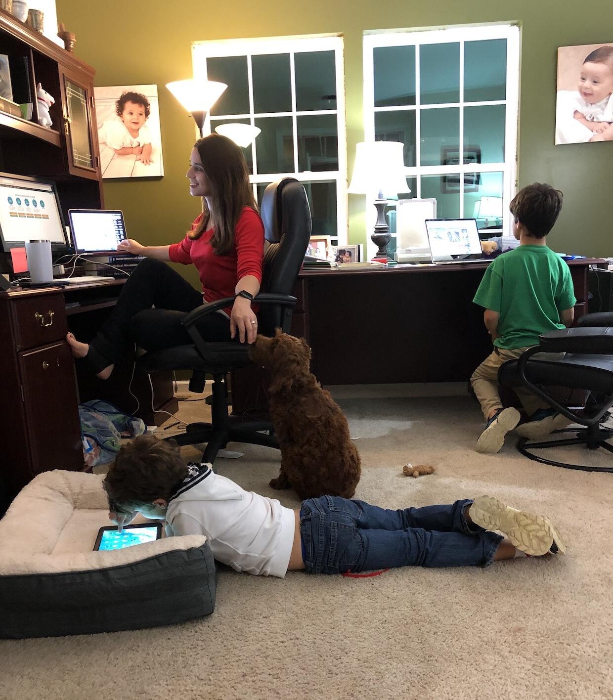 Faculty member teaching from their home office, with her elementary school-aged children doing homework on the floor