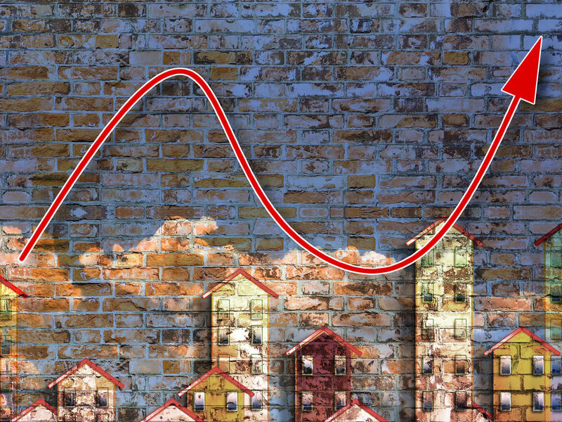 Graphic of a skyline with an arrow going up and down above it.