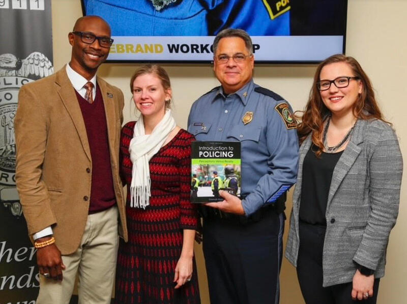 Four people standing next to each other. 