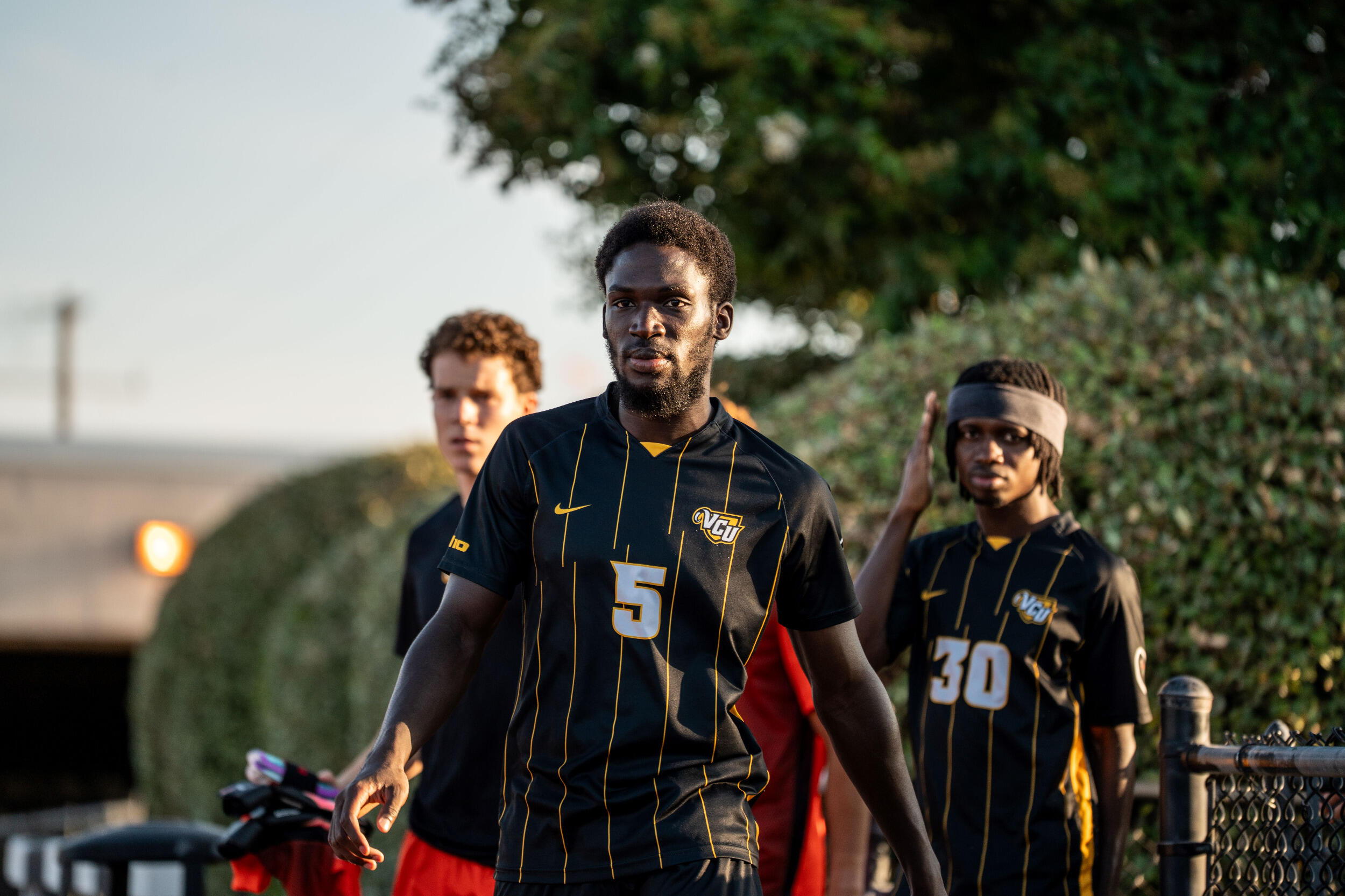 Three soccer players in black uniforms.