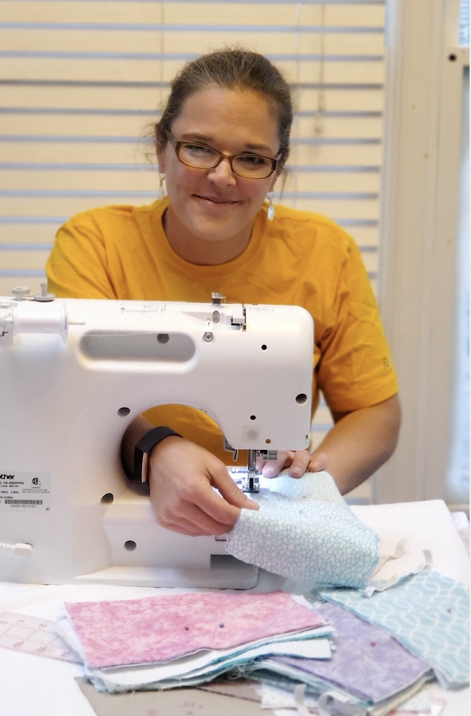 Person sitting at sewing machine.