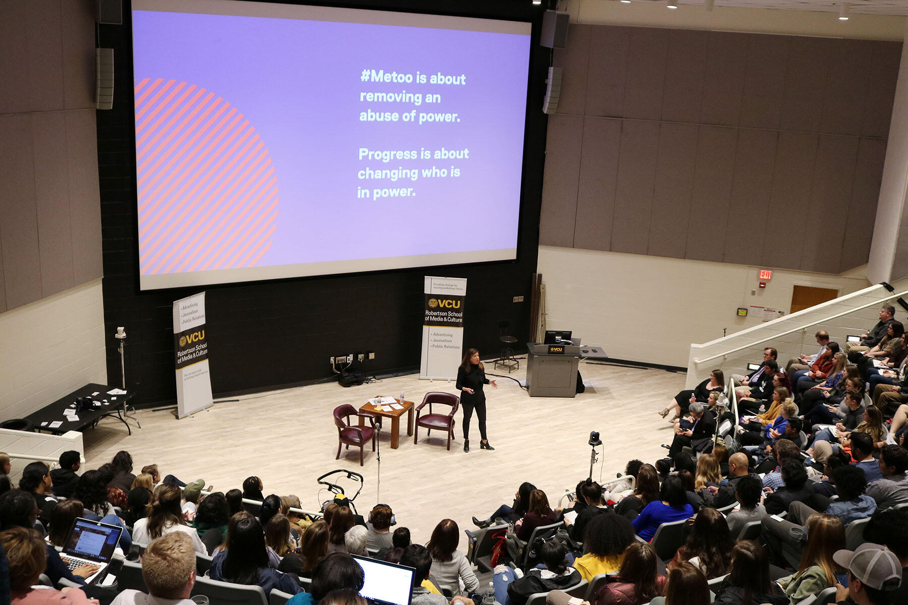 A speaker in front of a crowd of people.