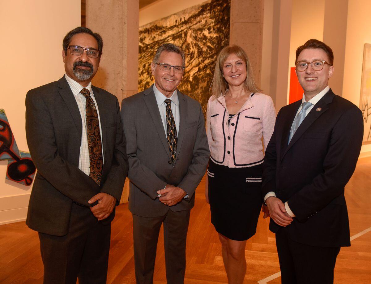 A photo of four people standing next to each other. 