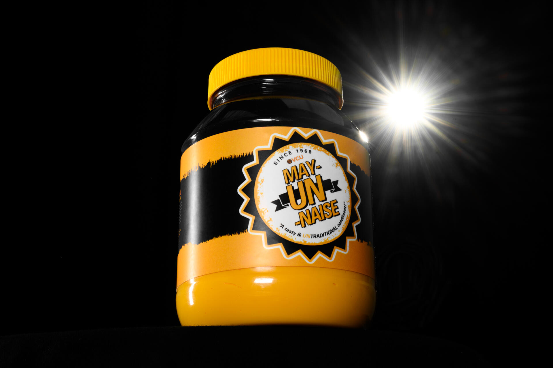 A jar of black and gold mayonnaise with a \"VCU May-UN-naise\" label.