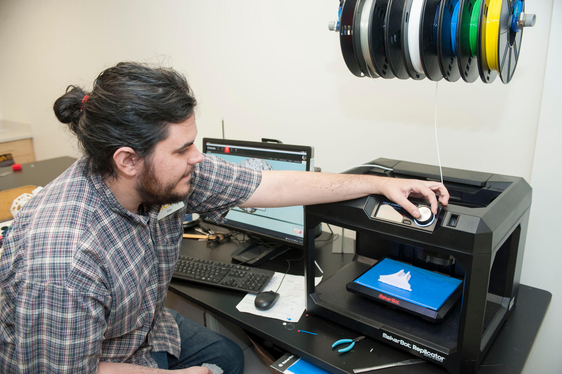 Alex Jones, a master's degree student in English, operates a 3-D printer in VCU Libraries' new space called The Workshop.
