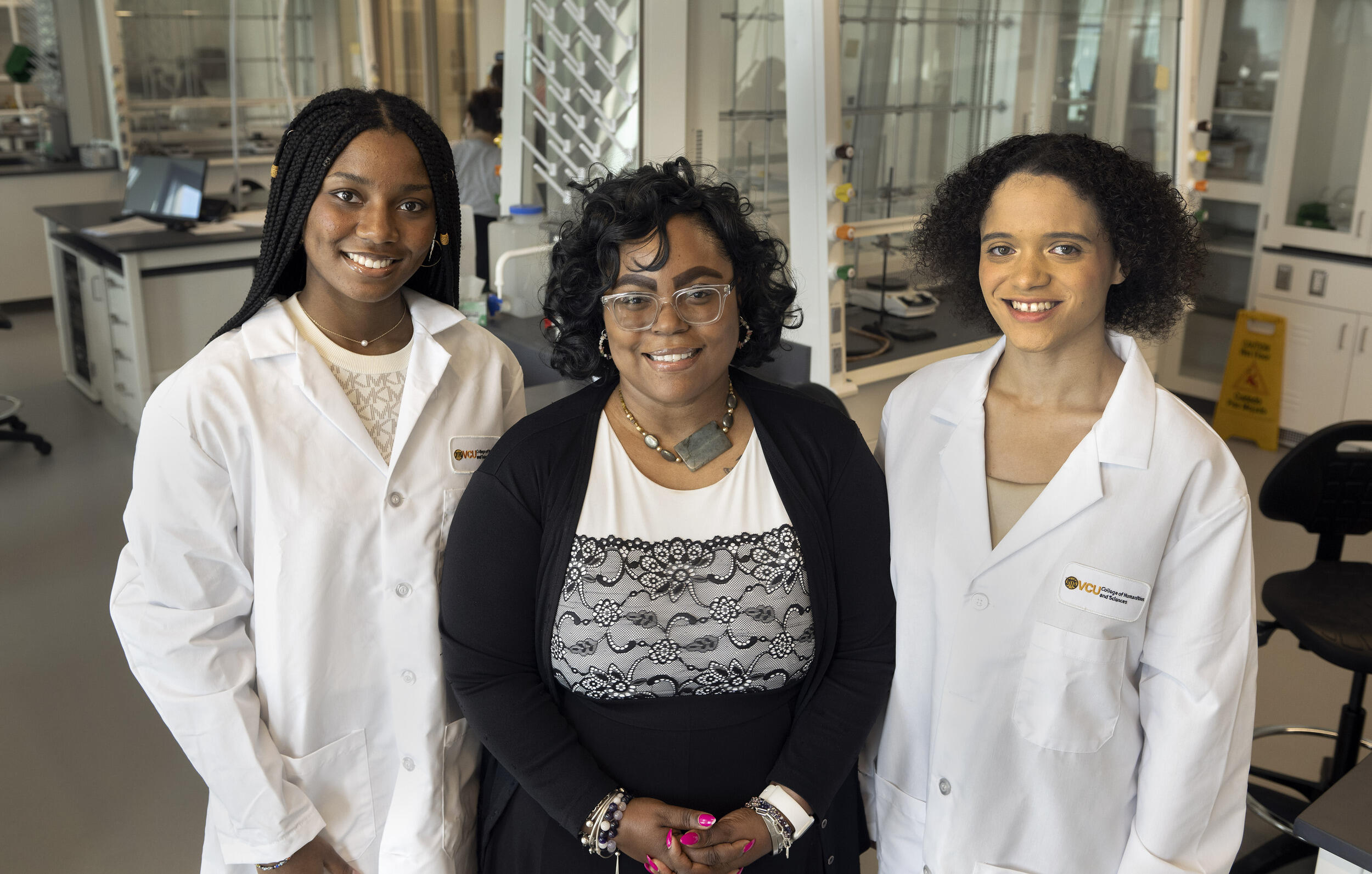A photo of three women standing next to each other. 