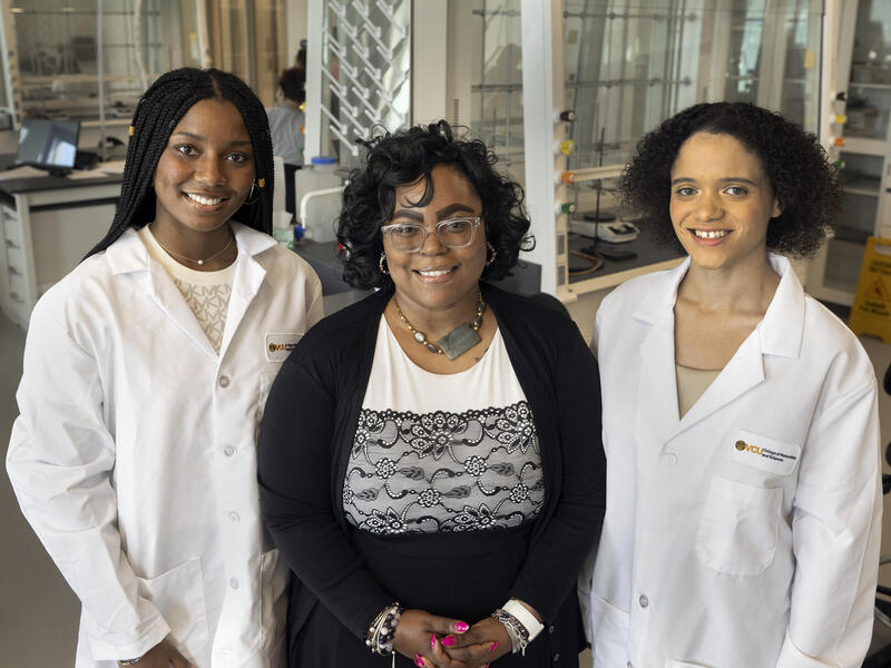 A photo of three women standing next to each other. 
