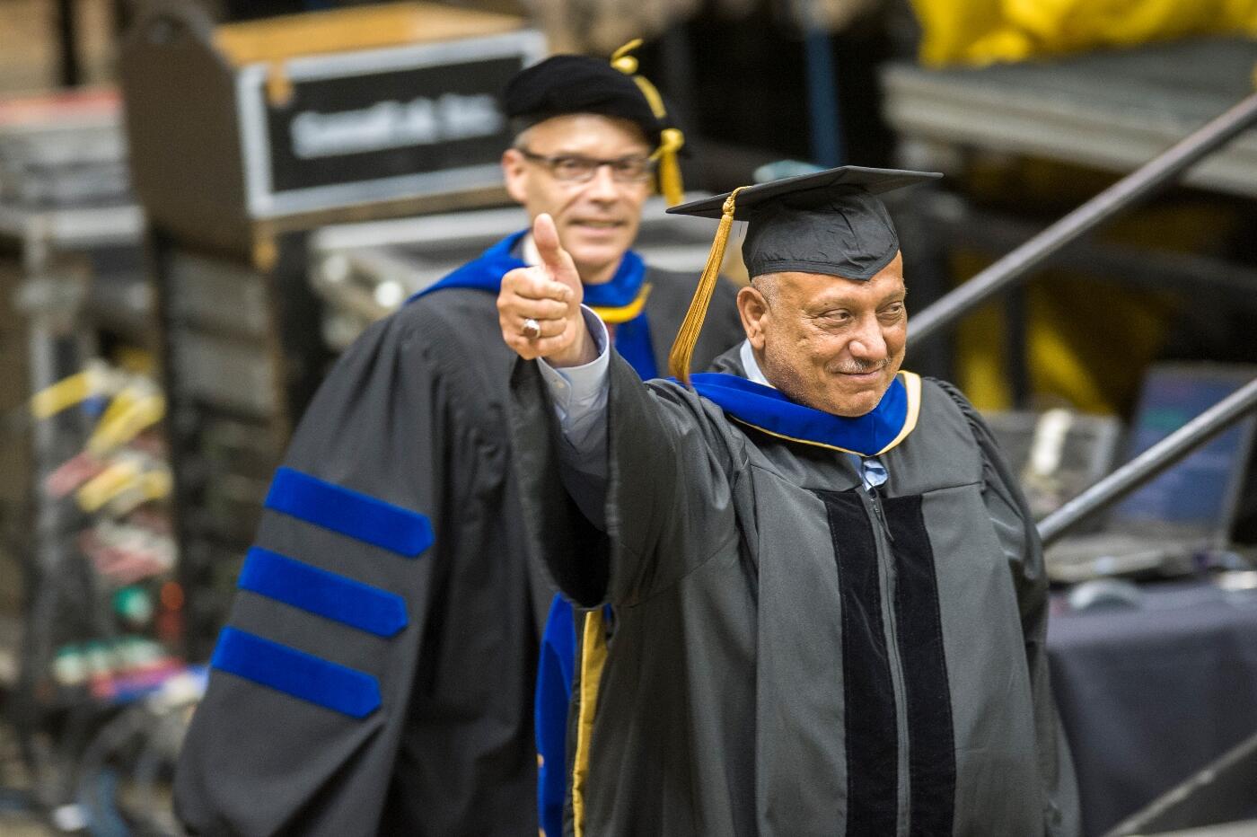 Jamal Aladajaei, Ph.D., gives a thumbs up to his family at the spring commencement ceremony.