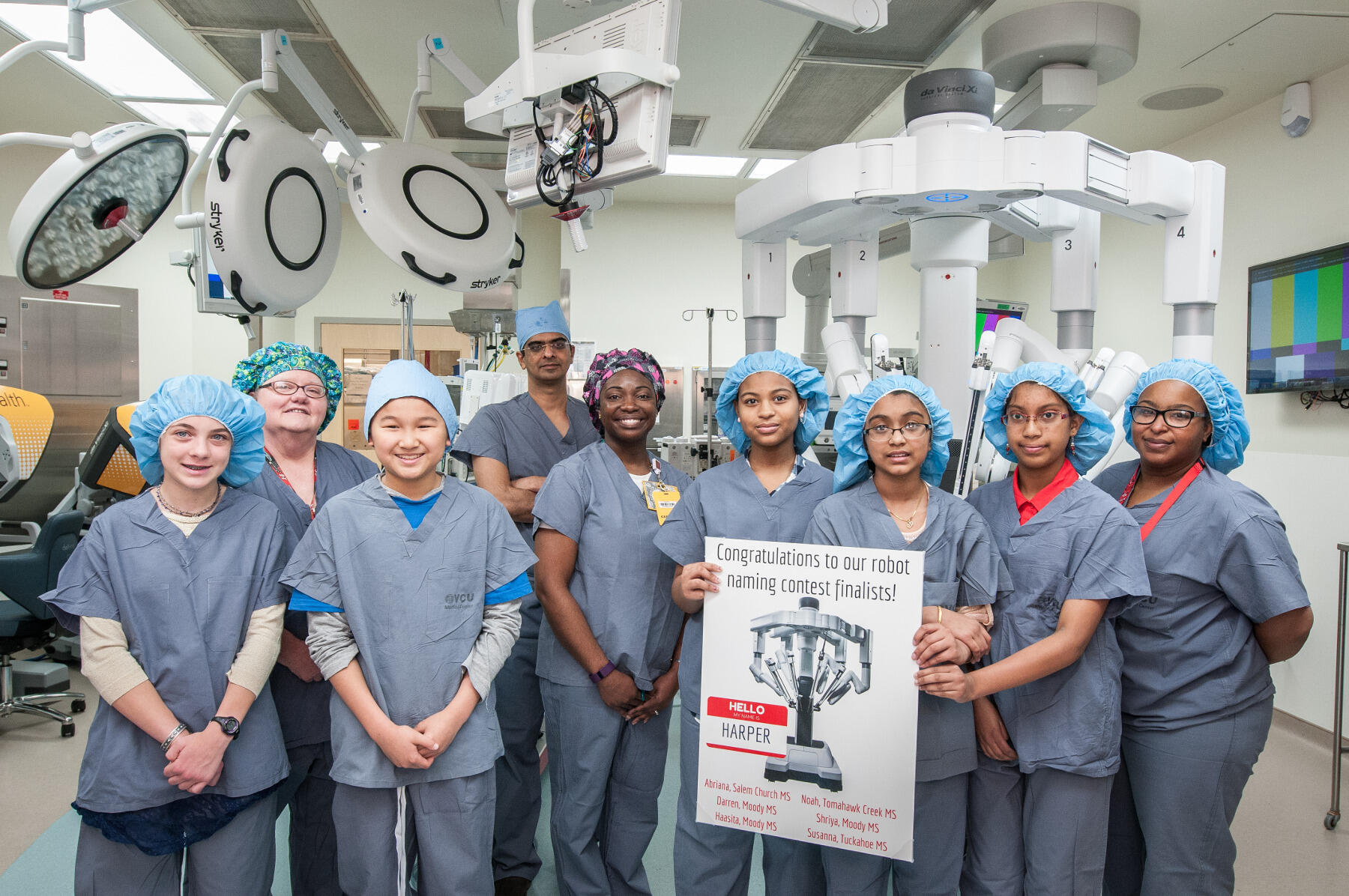 Five of the six Hume-Lee robot naming contest finalists stand with Regina Smithey, operating room transplant coordinator; Chandra Bhati, M.D., transplant surgeon; Yolonda Brown, specialty team manager for Robotics; and Tashana Taylor, surgical tech III, in the operating room where HARPER will be used.