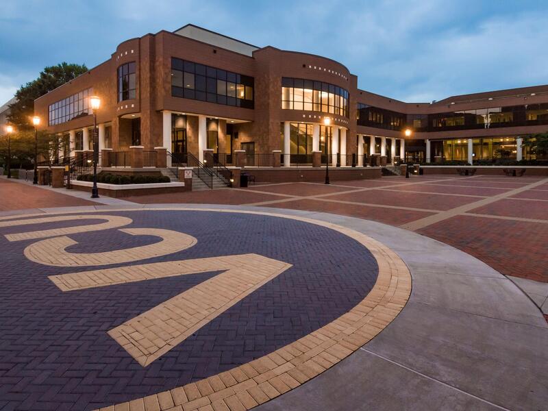 A photo of the VCU Student Commons building lit up at dusk. 