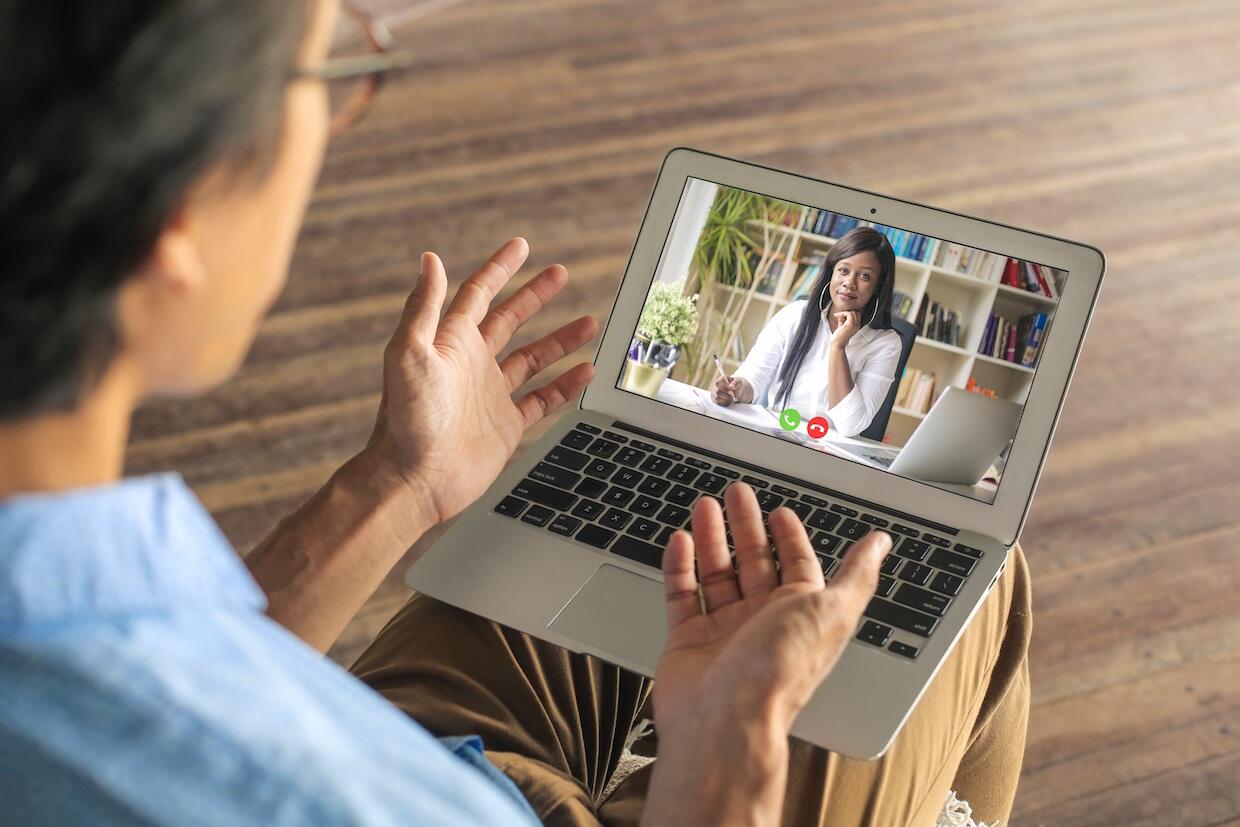 patient speaking with a counselor in a telehealth session. the counselor is on a laptop screen. 