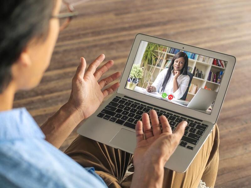 patient speaking with a counselor in a telehealth session. the counselor is on a laptop screen. 