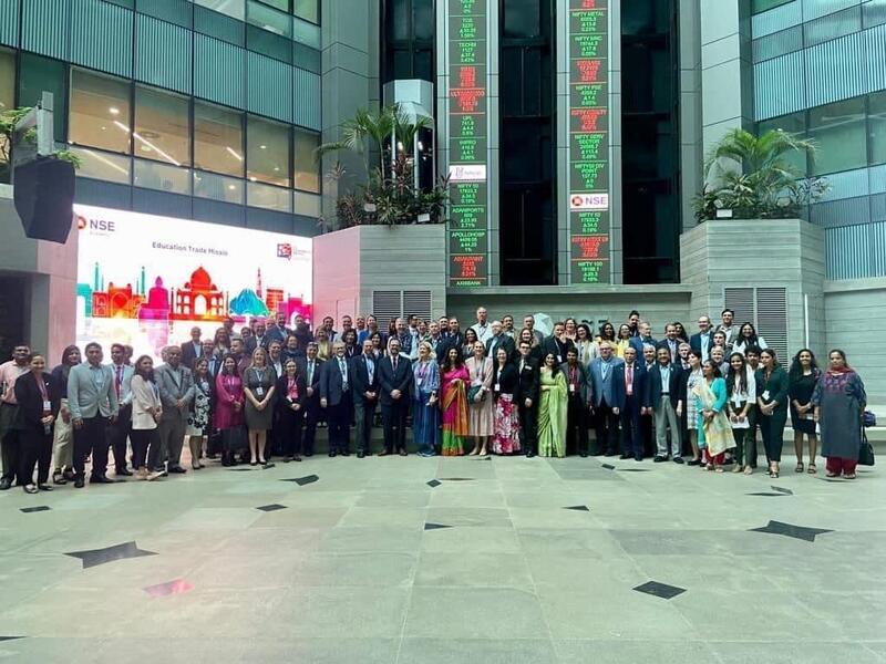 A large group of people standing in front of a stock exchange 