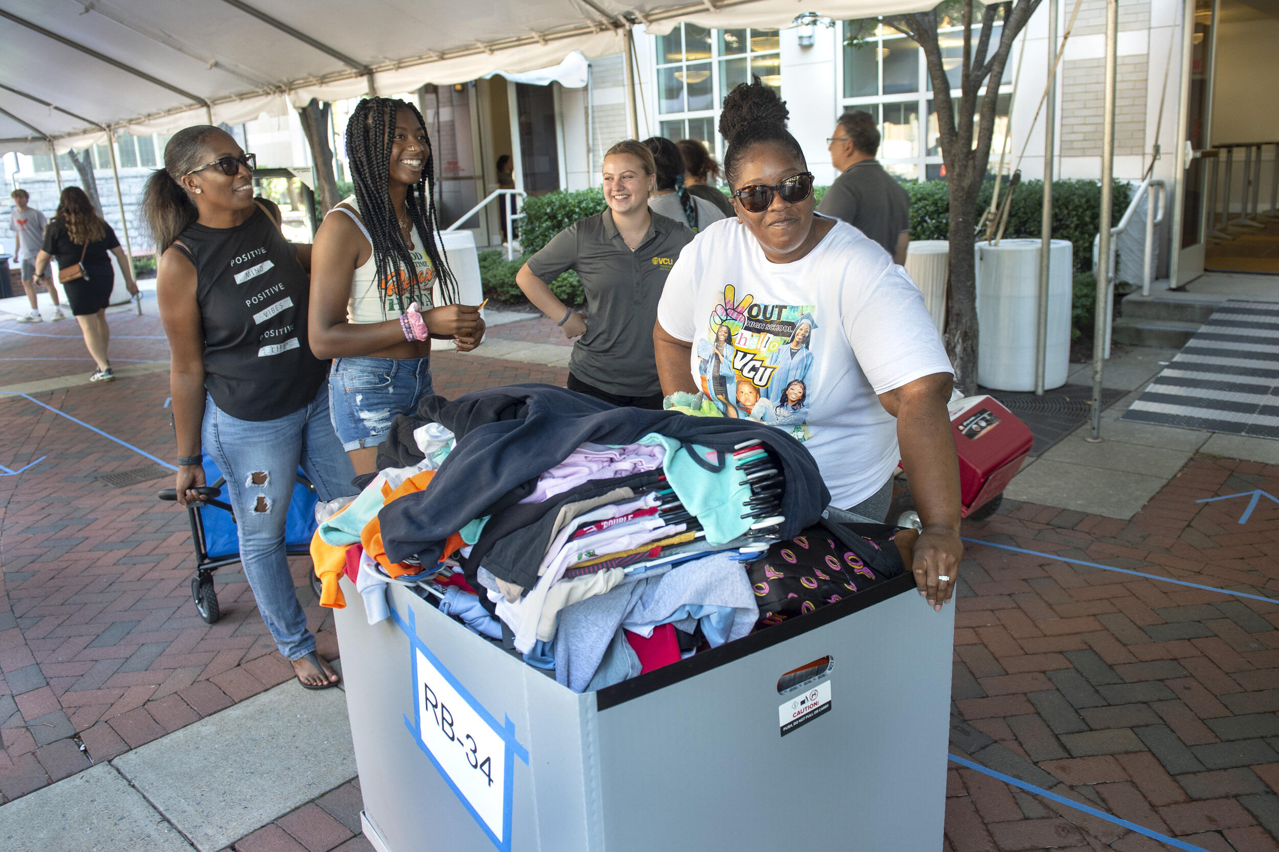 Four women standing around a rolling bin 