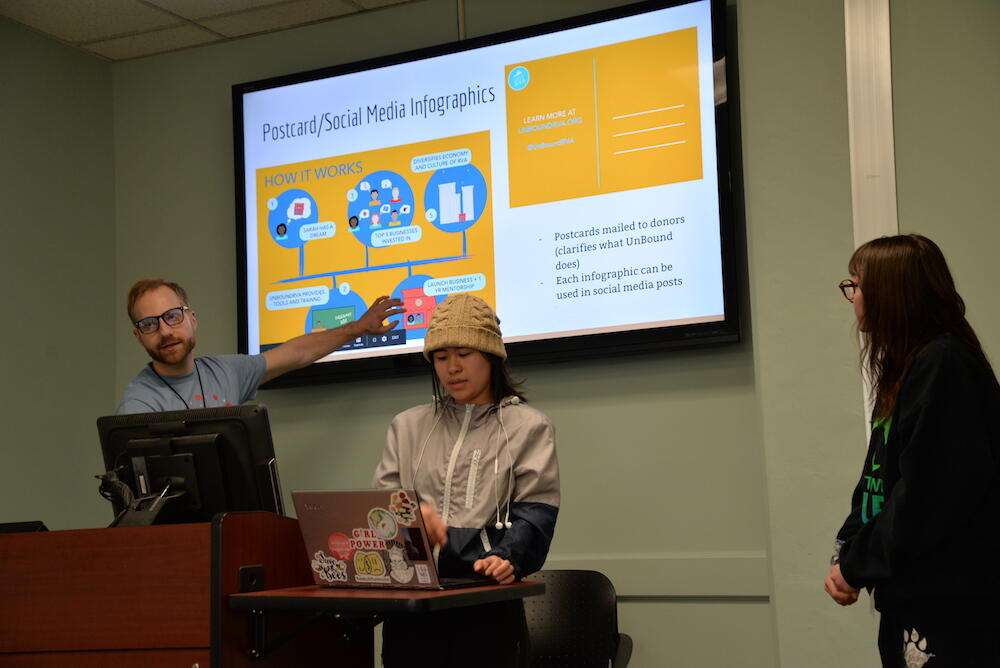 Aaron Keen, leader of the team that worked on UnBoundRVA, shows executive director Sarah Williams the team's final infographic design. (Photo by Brian McNeill, University Public Affairs)