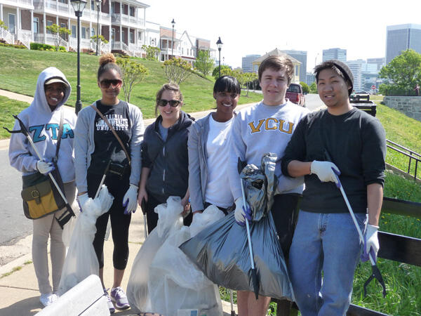 Paint the Town Green brought together volunteers from VCU, surrounding neighborhoods and Fort Lee. Together, they cleared trash in seven neighborhoods surrounding both campuses. Here, student volunteers take a break after reaching the end of their assigned street in the Oregon Hill neighborhood. Paint the Town Green was held on April 14. Photo by Mike Porter, Office of Communications and Public Relations. 
