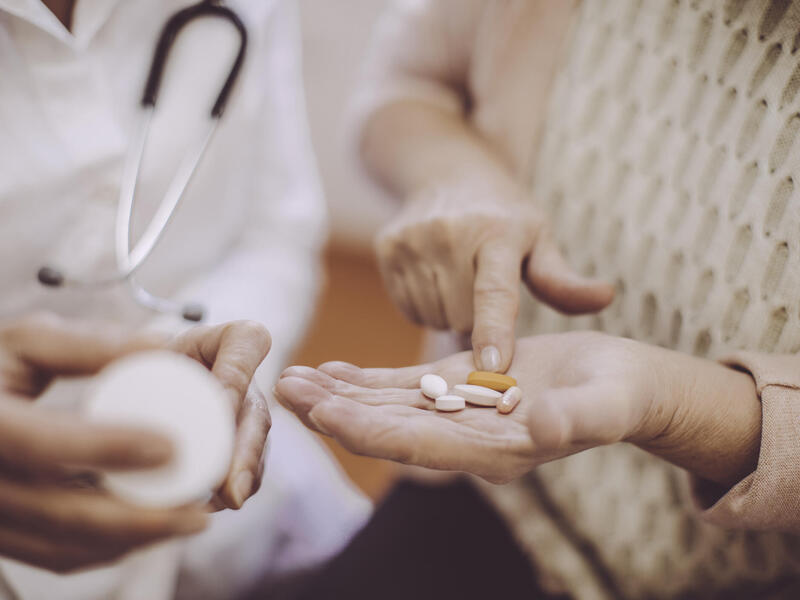 A close-up photo of two people standing side by side. On the left is a photo of a doctor holding a bottle of pills. On the right is a woman counting pills in her hand.