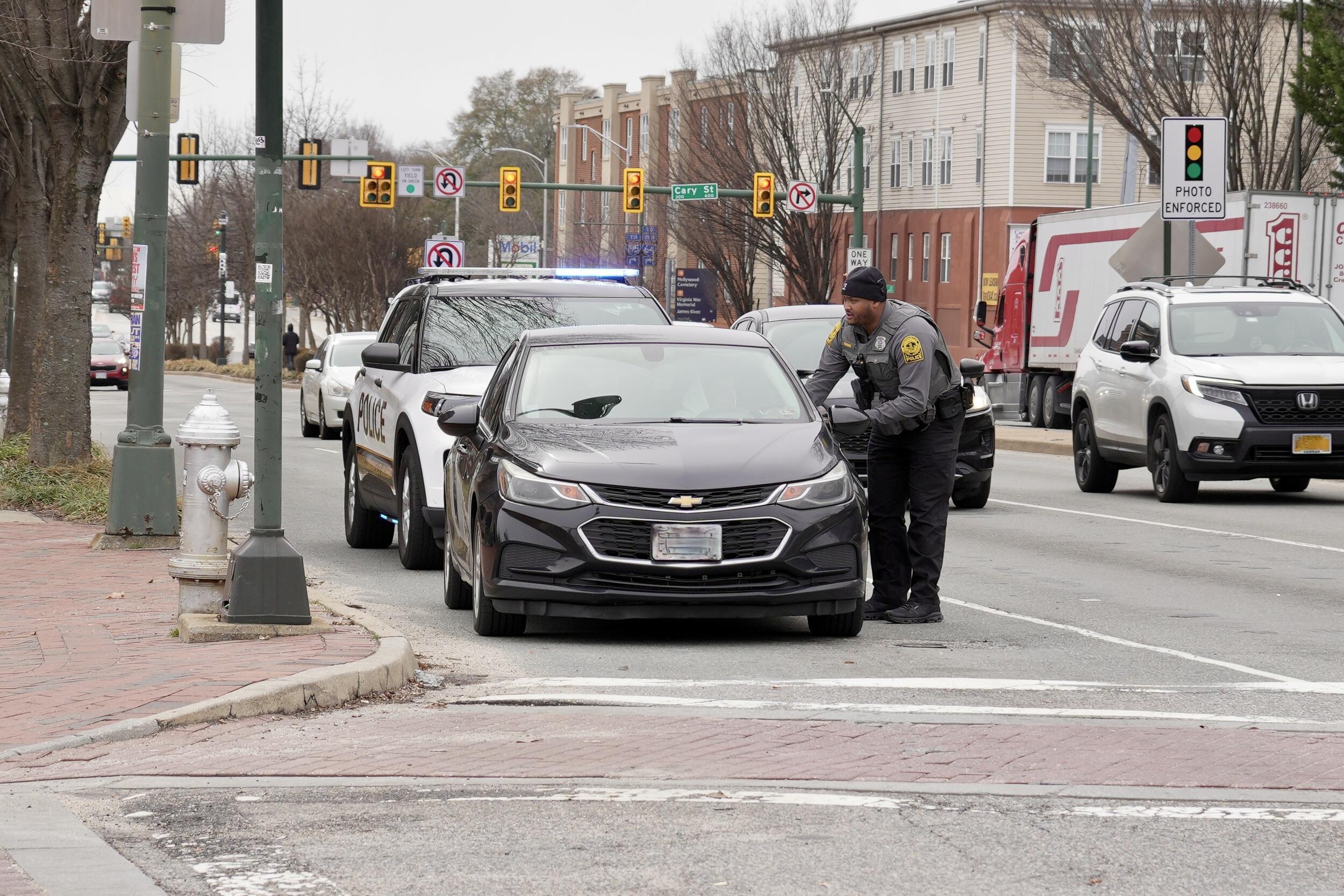 A photo of a police officer standing next to the driver side of a person's car. 