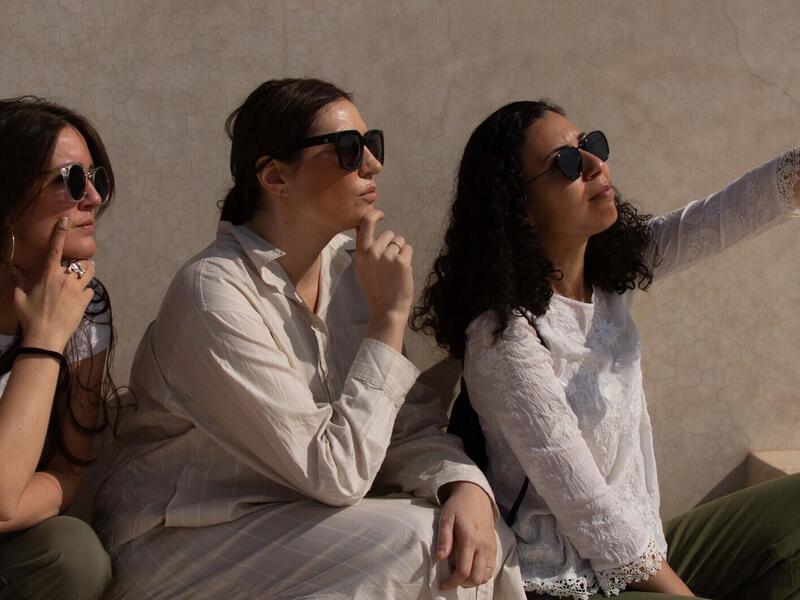 A photo of three people sitting and looking to the right.