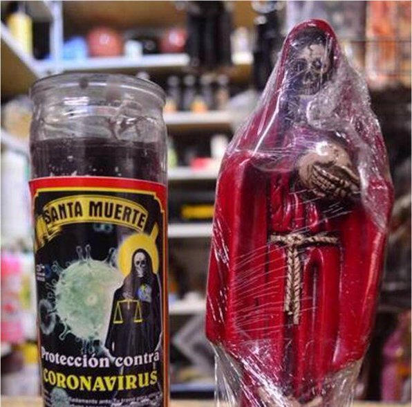 A black candle next to a figurine 
