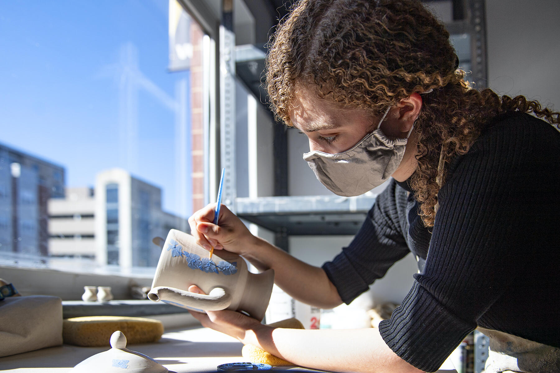 Madeleine Dugan working on a piece of pottery.