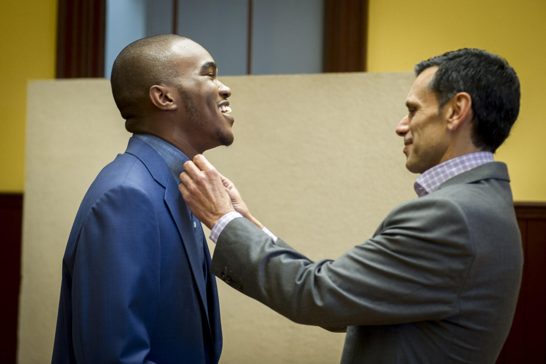 President Michael Rao, Ph.D., adjusts student Curtis Holloway's tie.