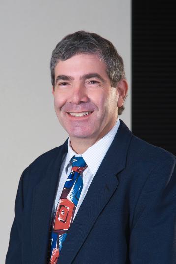  Steven Woolf, M.D. smiling at the camera and wearing a suit 