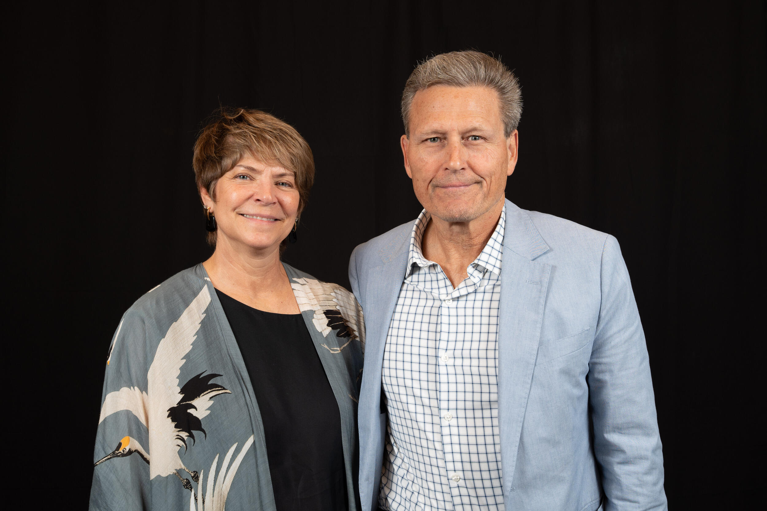 A photo of a man and a woman from the waist up. 