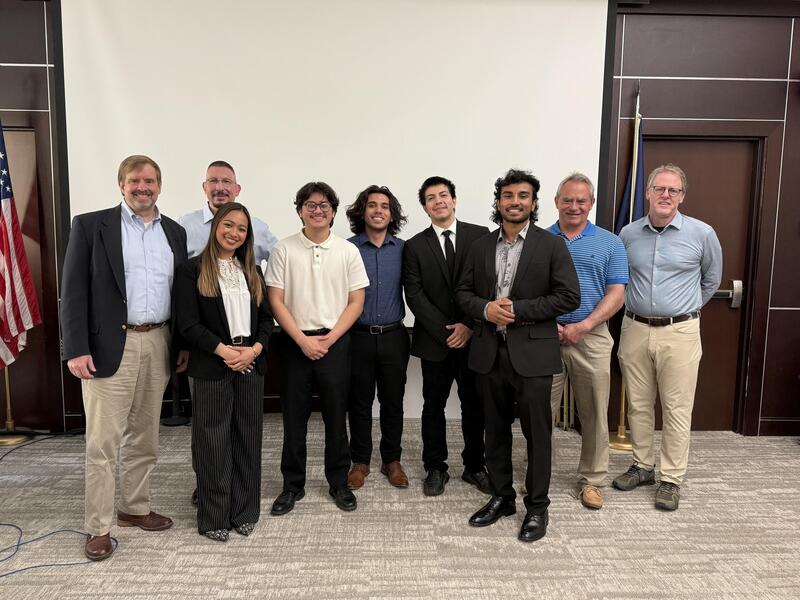A group photo of eight people standing. 