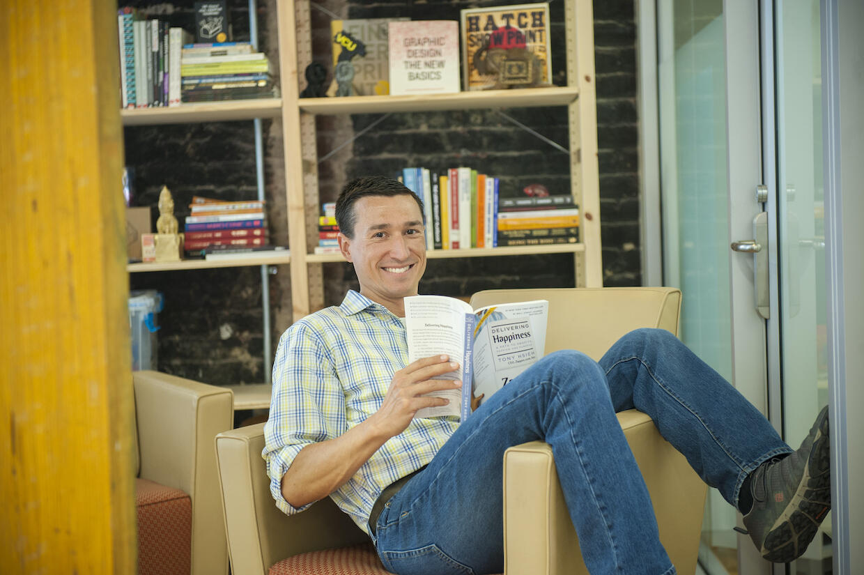 Garret Westlake sitting in a chair and reading a book