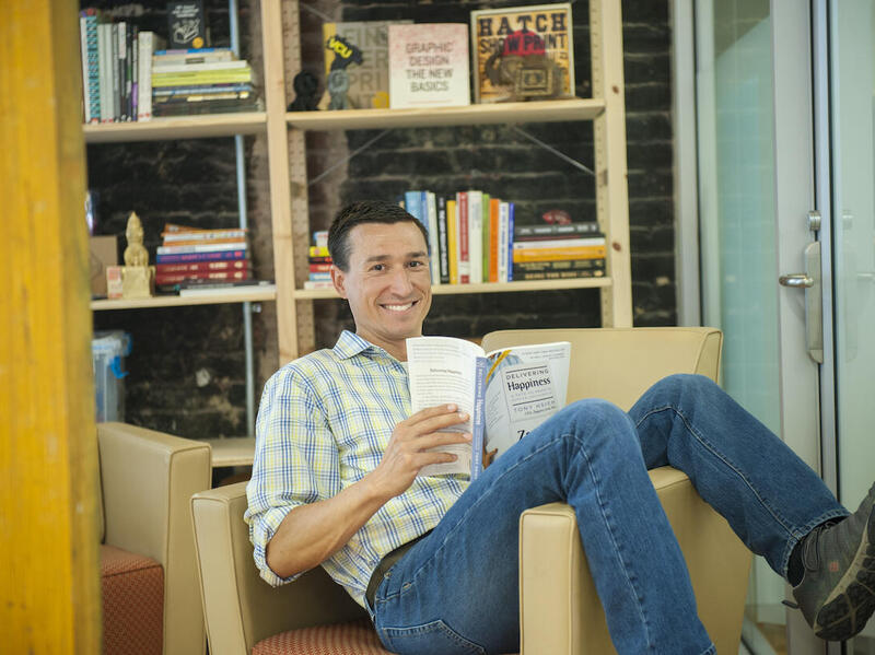 Garret Westlake sitting in a chair and reading a book