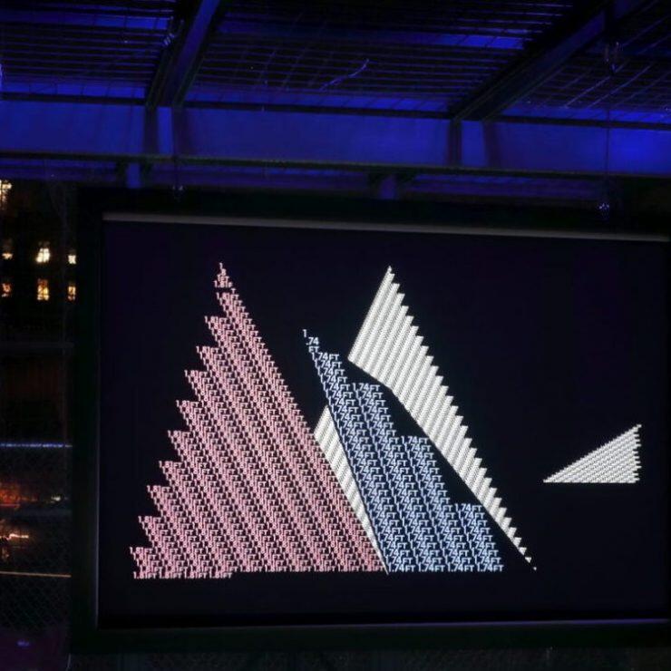 A photo of an illustration of triangles made with lights. 