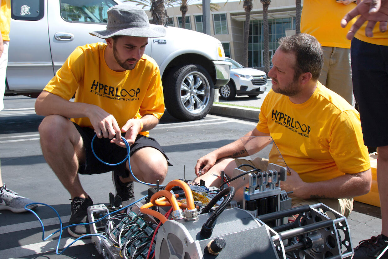 Matthew Kozak and Patrick Welch work on the pod at the Hyperloop finals in Hawthorne, California. (Photo by Kendra Gerlach, VCU College of Engineering)