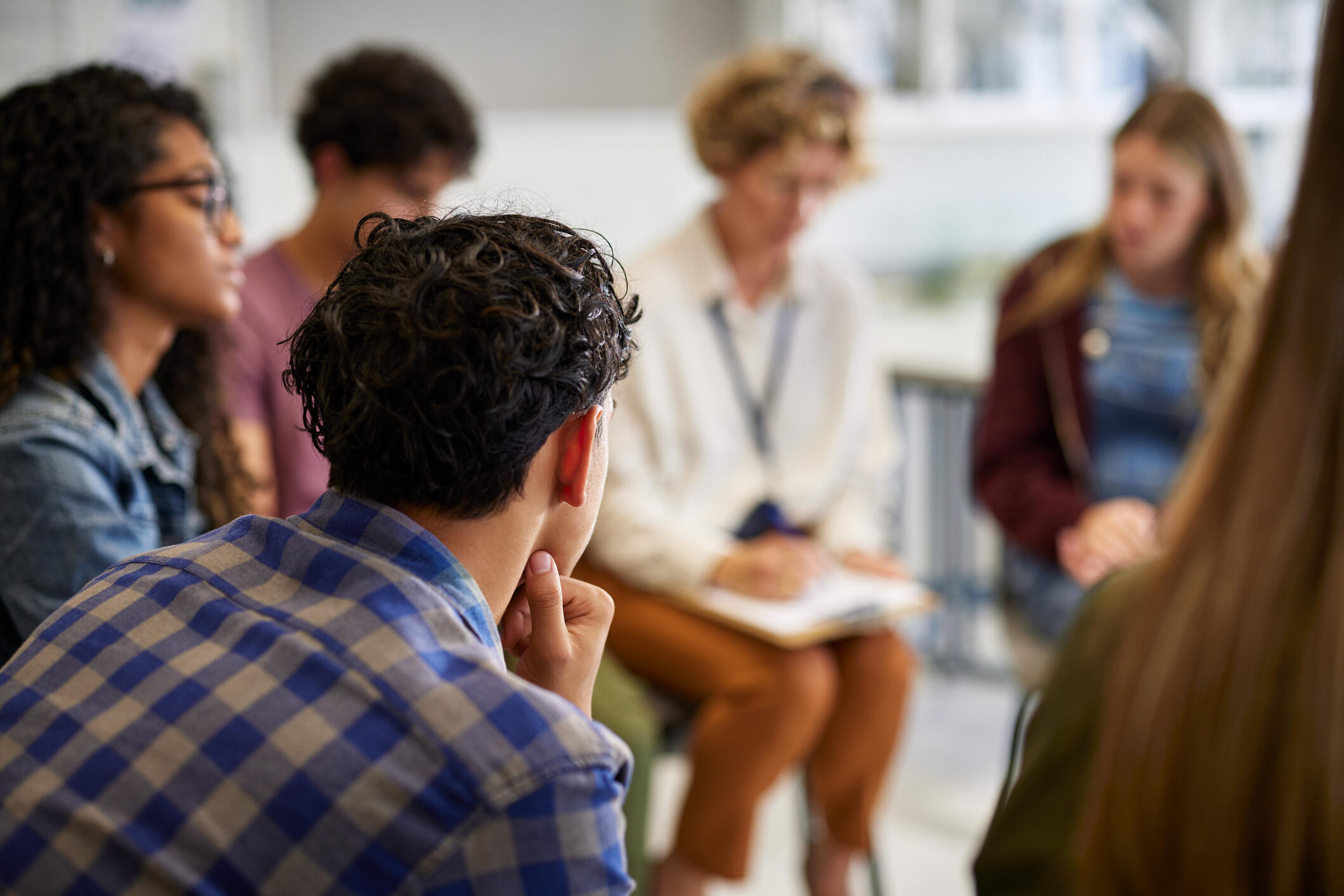 A photo of six people sitting in a semi-circle. 