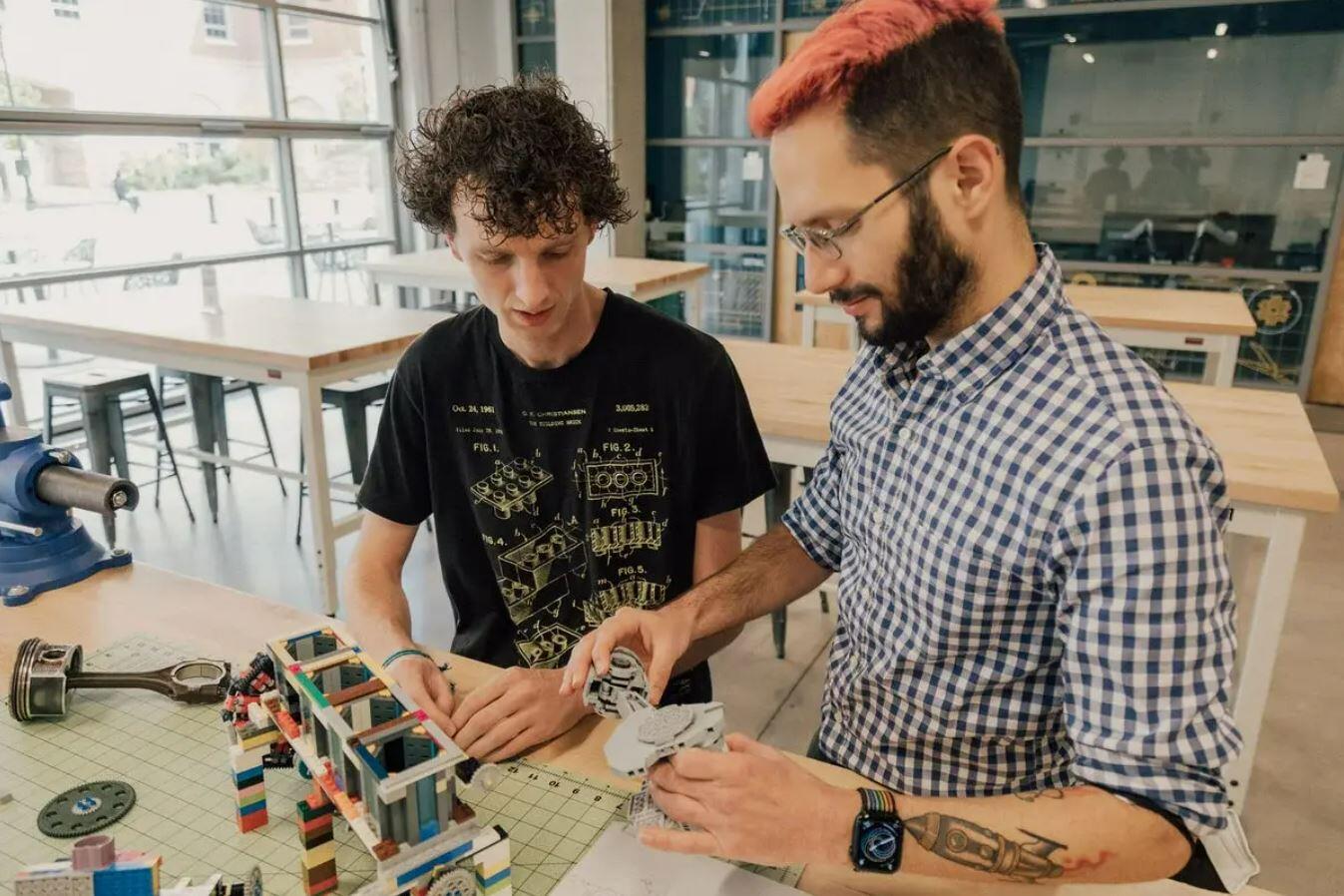 Two men building objects with legos