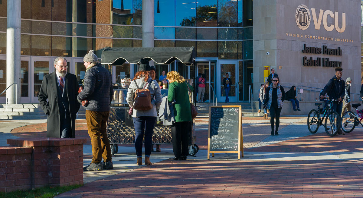 Mandy Patinkin speaks with Director Michael Offerin between takes of filming an episode of "Homeland" season seven next to a fictitious coffee cart in front of Cabell Library.