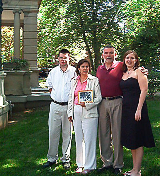 The Ward family poses with a photo of Jean and Hugh Haskins on Ashley Ward's graduation day.