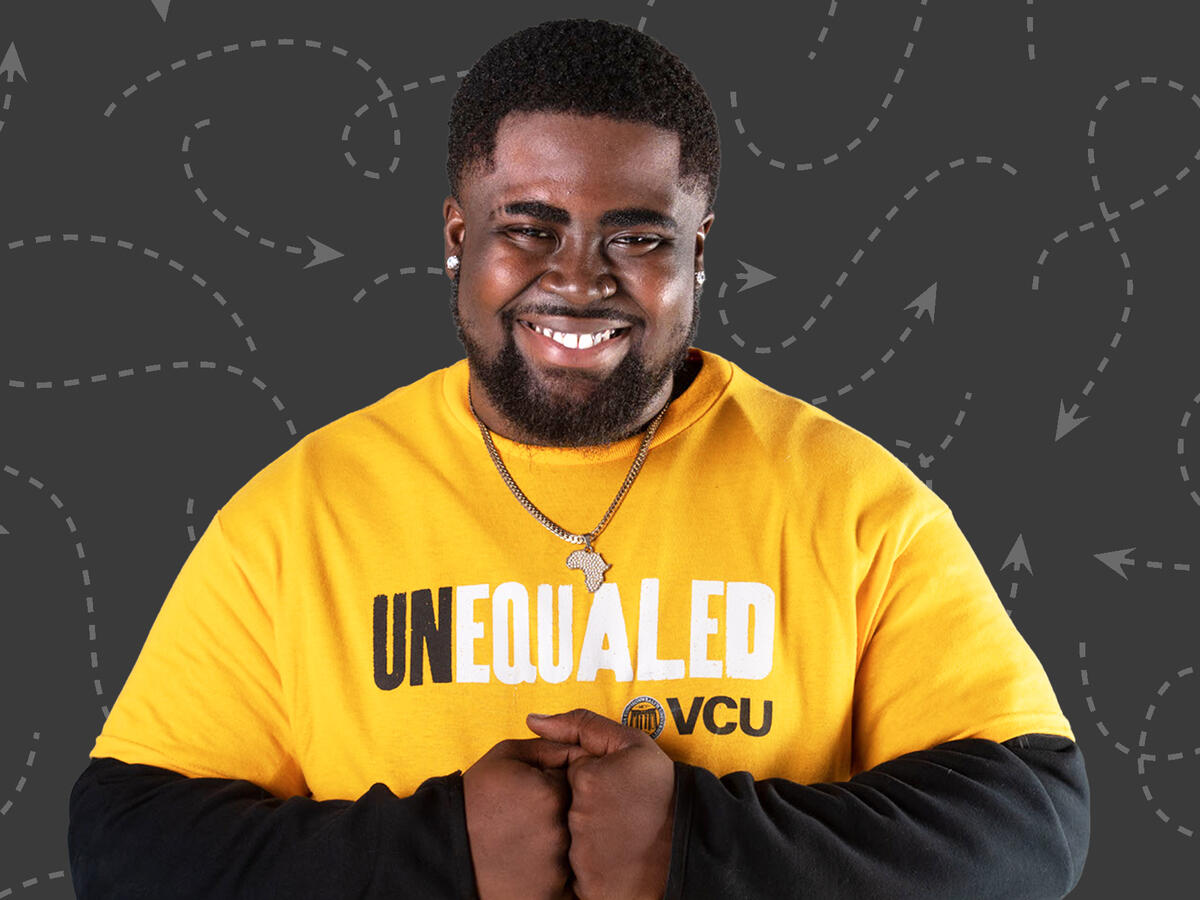 A man smiling at the camera with his fists pressed together 