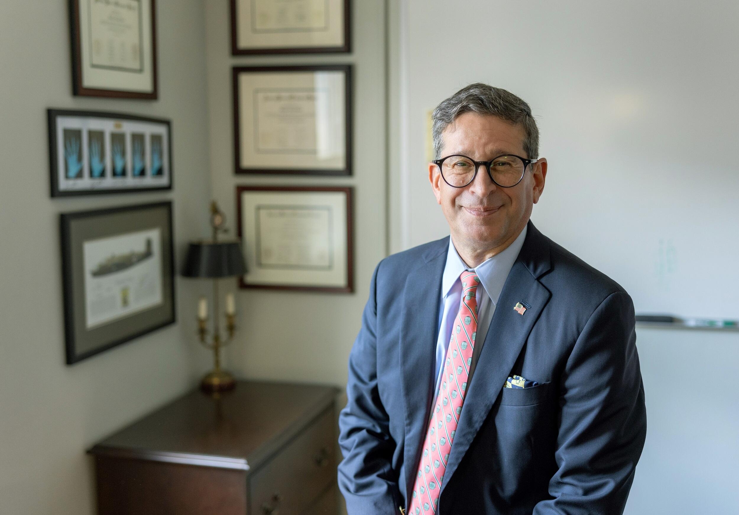 A photo of a man sitting in an office. 