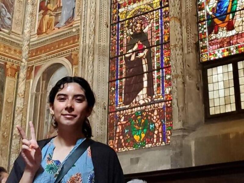 Ivania Del Cid standing in front of stain glass windows 