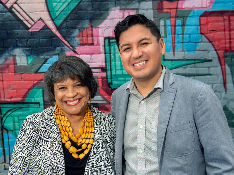 A photo of two people from the cheswt up. There is a woman on the left and a man on the right 