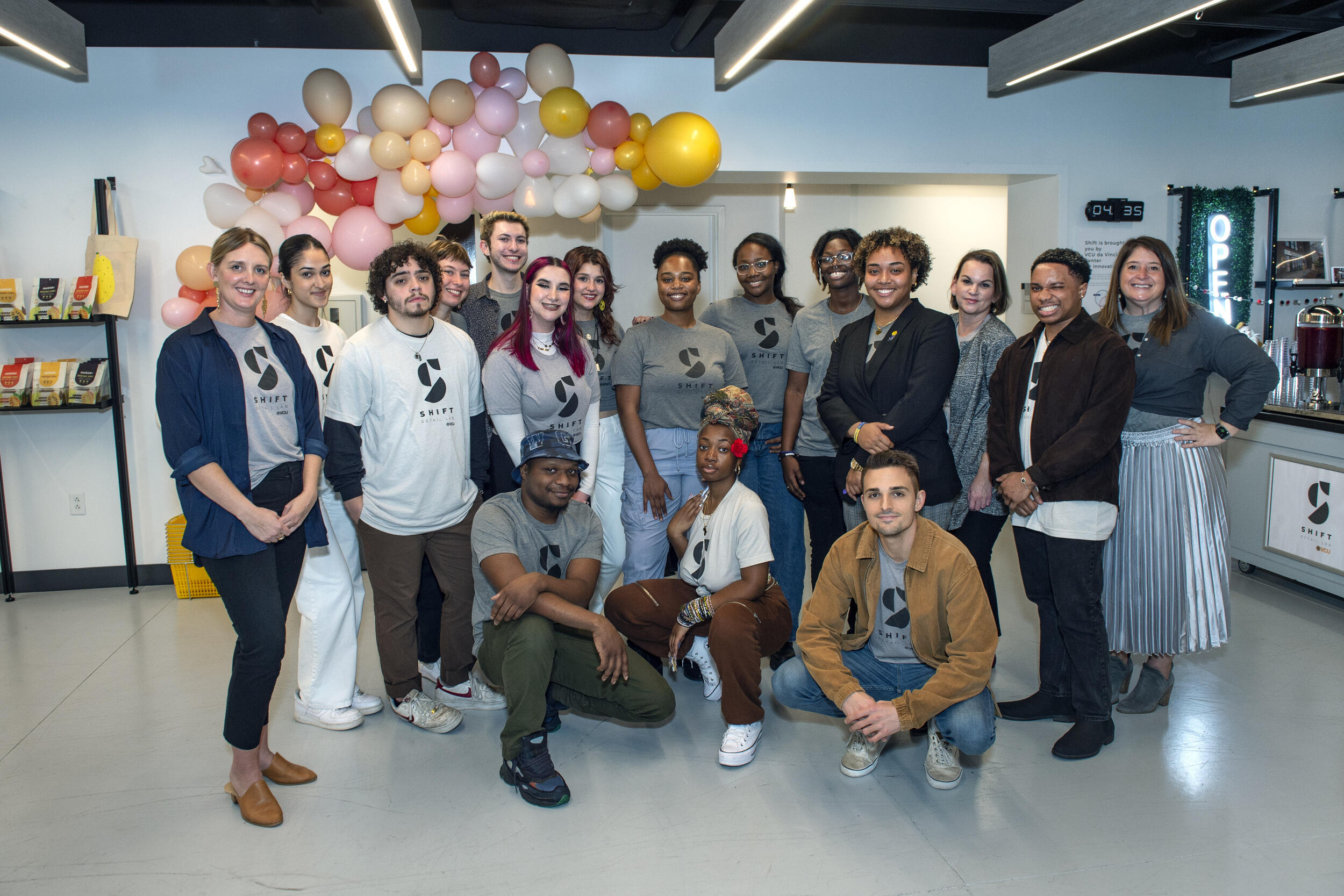 Seventeen people standing and kneeling next to each other. 