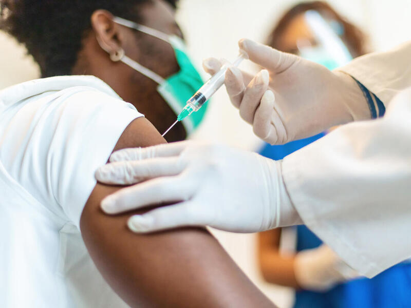 A person receiving a hypodermic needle shot.