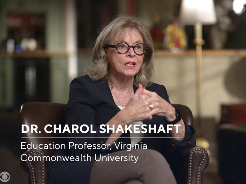 A woman sitting in a dark brown armchair speaking. There is white text that reads \"DR. CHAROL SHAKESHAFT Education Professor, Virginia Commonwealth University\"