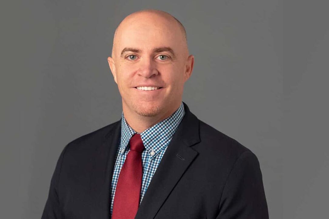 Brendan Dwyer, Ph.D. smiling at the camera in a suit and tie