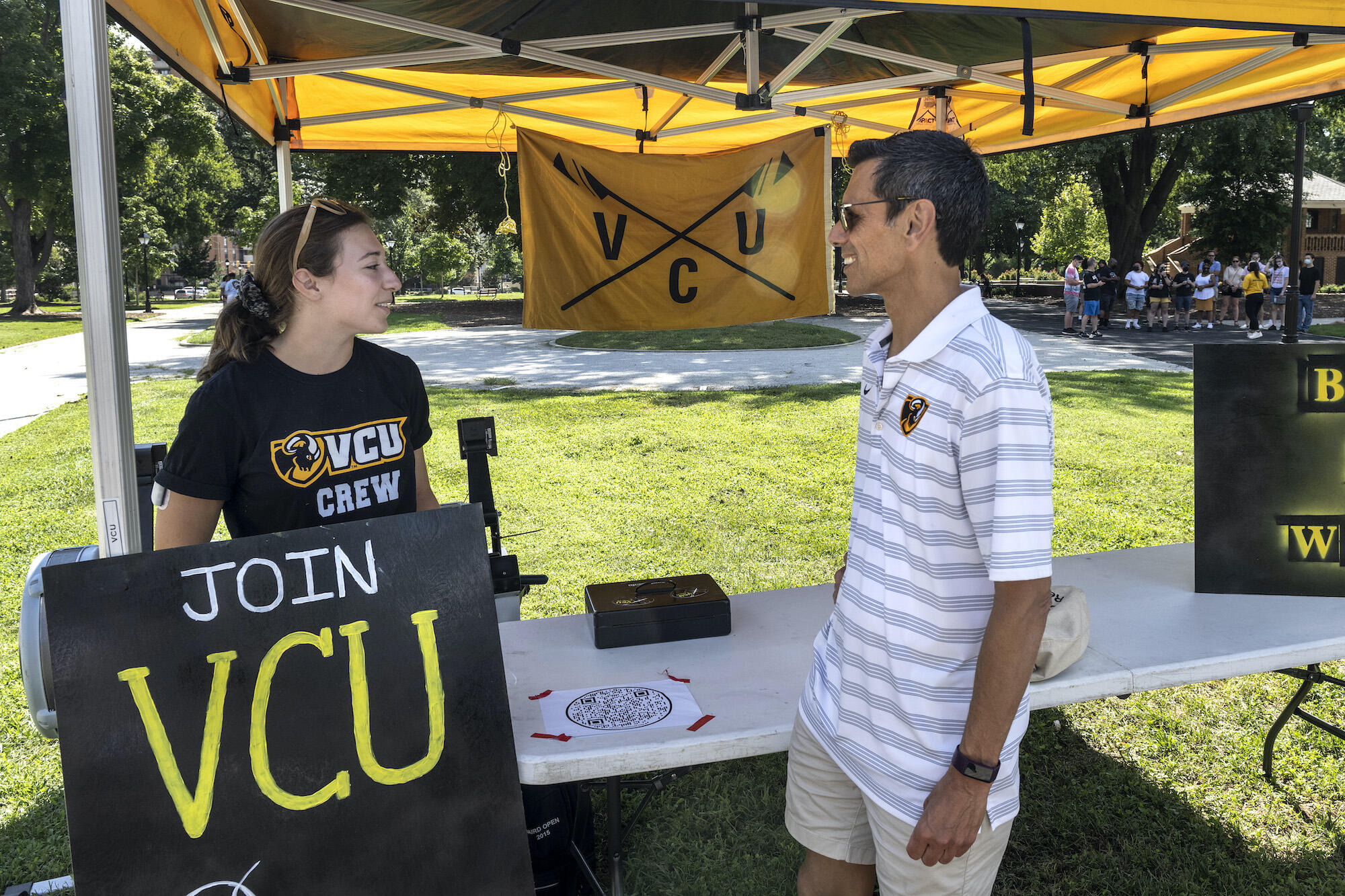 VCU President Michael Rao, Ph.D., speaks with student Anna Berberoglu who was in Monroe Park to recruit members for the crew team. 